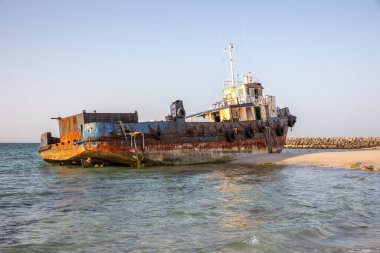 Eski terk edilmiş balıkçı teknesi Sharjah, Birleşik Arap Emirlikleri 'nde bir sahilde paslanıyor.
