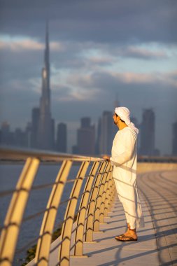 Emirati adamı Dubai 'de El Jaddaf rıhtımında Burj Halife ile birlikte.
