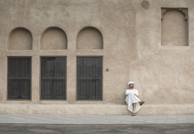 Dubai 'nin tarihi Shindagha bölgesinde geleneksel giyinmiş Arap bir adam.