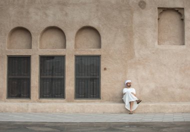 Dubai 'nin tarihi Shindagha bölgesinde geleneksel giyinmiş Arap bir adam.