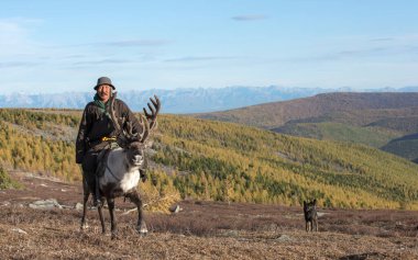 Kuzey Moğolistan 'daki ren geyikleriyle geleneksel bir deel giymişti.