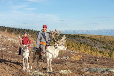 Kuzey Moğolistan 'daki ren geyikleriyle geleneksel bir deel giymişti.