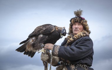 Bayan Ulgii, Moğolistan, 4 Ekim 2015: Kartal avcısı Altai Altın Kartalı ile ata biniyor