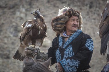 Bayan Ulgii, Moğolistan, 4 Ekim 2015: Kartal avcısı Altai Altın Kartalı ile ata biniyor
