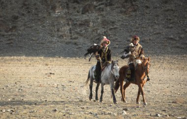 Bayan Ulgii, Ekim 2015: Kazak kartal avcıları geleneksel giysiler içinde, kartalıyla ata biniyorlar.