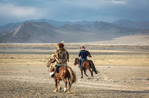 バヤン ウルギ2015年10月 カザフスワシのハンターが伝統的な服を着て 鷲と馬に乗って — ストック写真