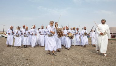 Khadal, Umman, 28 Nisan 2018: Geleneksel giysiler içinde bir at yarışını izleyen uğursuz adamlar.