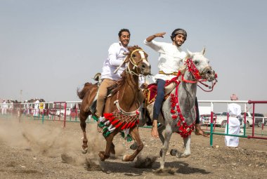 Ibri, Oman, 28th April 2018: omani men at a traditional horse race event where young riders show their skills clipart