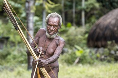 Ugem Köyü, Baliem Vadisi, Batı Papua, Endonezya - 13 Şubat 2016: Yay ve oklu Dani kabilesi adamı