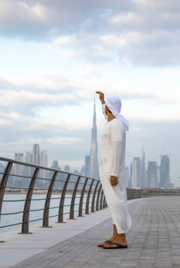 Emirati adamı Dubai 'de El Jaddaf rıhtımında Burj Halife ile birlikte.