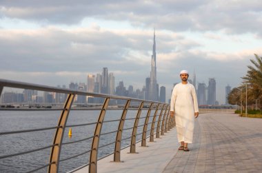 Emirati adamı Dubai 'de El Jaddaf rıhtımında Burj Halife ile birlikte.