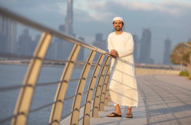Emirati adamı Dubai 'de El Jaddaf rıhtımında Burj Halife ile birlikte.