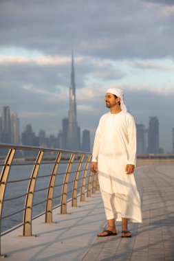 Emirati adamı Dubai 'de El Jaddaf rıhtımında Burj Halife ile birlikte.