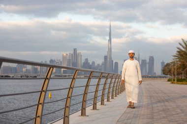 Emirati adamı Dubai 'de El Jaddaf rıhtımında Burj Halife ile birlikte.