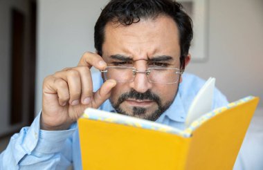 middle aged man with poor eyesight trying to read notes clipart
