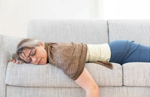 middle aged woman sleeping on a sofa