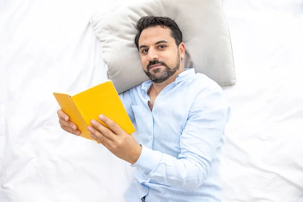 Middle aged arab man reading in bed