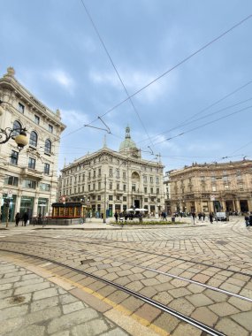 Tarihi binalar ve kaldırım taşları üzerinde yürüyen insanlarla Cordusio Meydanı 'nın kentsel manzarası.