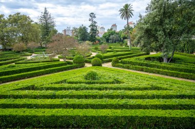 Belem, Lizbon, Portekiz 'de çalılar, ağaçlar ve açık manzaralı resmi bir bahçe manzarası.
