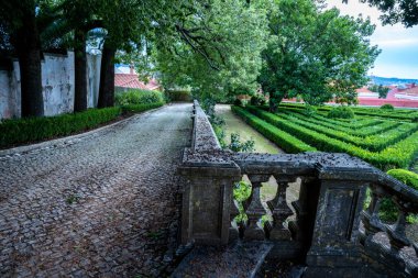 Belem, Lizbon, Portekiz 'deki resmi bir bahçeye bakan tarihi bir taş merdivenden simetrik manzara. 4 Ekim 2025.