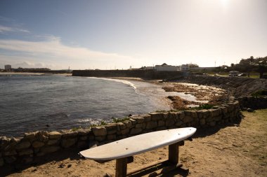 Penis Portekiz 9 Kasım 2025. Sığınak olarak kullanılan bir sörf tahtası, evleri ve kıyı şeridi olan bir körfezin üzerinde duruyor..