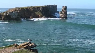 Peniche Portekiz 'deki yüksek kıyı kayalıklarına yaklaşan dalgalar