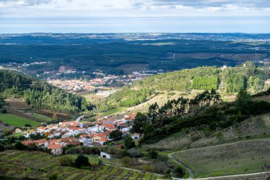 Alenquer Portekiz 29 Kasım 2025. Ormanlık tepeler ve tarımsal teraslar arasında bir köyün kırmızı çatıları beliriyor