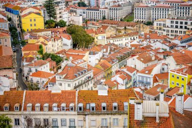 Lizbon Portekiz Aralık 05, 2025. Lizbon 'un merkezinde yoğun konut binaları ve kırmızı kiremit çatılar bulutlu koşullar altında yamacı kaplıyor..