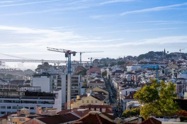 Lizbon Portekiz Aralık 06: 2025 Bairro Alto 'nun çatıları, inşaat vinçleri ve asma köprü manzarası