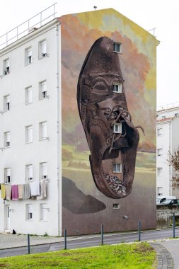 Lizbon, Aralık 07, 2025. Lizbon 'da bir apartmanın yan duvarını boyalı büyük bir ayakkabı tablosu kaplıyor..