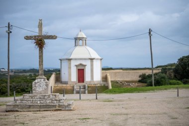 Cabo Espichel tapınağının içindeki küçük bir kilisenin önünde yıpranmış bir taş haç duruyor..