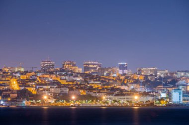 Lizbon Portekiz 24 Aralık 2025. Geniş şehir manzarası, geceleri aydınlatılmış yerleşim yerleri ve modern ofis kulelerini gösteriyor..