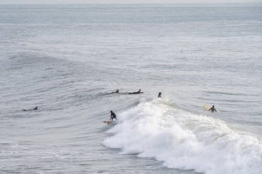Estoril Portekiz 17 Aralık 2025. Bazı sörfçüler sakin sularda dalgaları beklerken sörf tahtalarında yüzerler..