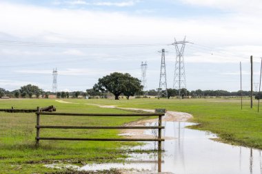 Barroca de Alva Lisbon Portekiz Kasım 19 2025. Kırsal çayır, ahşap çit çamurlu yol ve uzaktan elektrik iletim kuleleri..