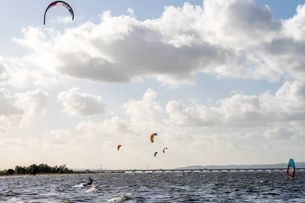 Alcochete Portekiz 19 Aralık 2025. Rüzgarsörfçüler sığ Tagus nehri sularında yelken açar ve yelken açarlar. Rüzgâr nehir boyunca eserken..