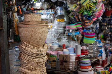 Bangkok Tayland 16 Ocak 2026. Khlong Toei pazarında sergilenen sepet, kap kacak ve mutfak eşyalarıyla ev eşyaları tezgahı..