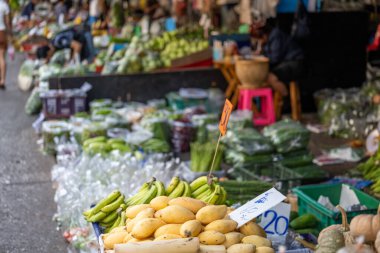 Bangkok Tayland 16 Ocak 2026. Khlong Toei pazarında sergilenen mango muzları ve sebzeler..