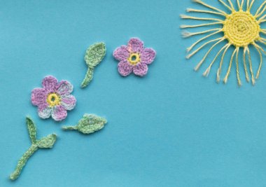 Aquamarine arka planında örülmüş ürünlerin bir kompozisyonu var. Çiçekler ve güneşli bir bahar ya da yaz gününün taklidi.