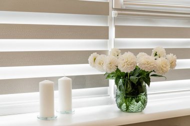 In a small massage parlor, customers enjoy a peaceful ambiance with fresh flowers and soft lighting. The space invites relaxation and comfort during a busy working day.