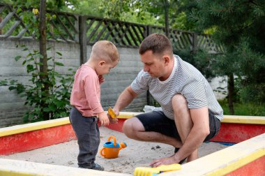 Bir baba çocuğuyla kum havuzunda karşılaşır. Sıcak bir öğleden sonra huzurlu bir arka bahçede yeşilliklerle çevrili oyuncaklarla oynarken eğlenceli anları paylaşıyorlar..