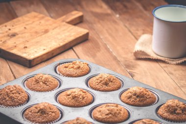 Bir grup muffin, ahşap bir masadaki teneke kutunun içinde.