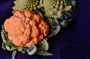 Sebze grubu. Siyah arkaplanda farklı renkte lahanalar.