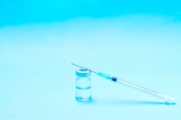 Seringa Cima Uma Garrafa Para Colocar Uma Vacina Fundo Azul — Fotografia de Stock