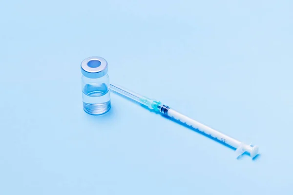 Spritze Neben Einer Flasche Einen Impfstoff Auf Blauem Hintergrund Platzieren — Stockfoto