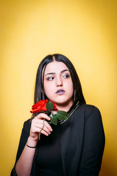 Adolescente Con Ropa Negra Fondo Amarillo Sosteniendo Una Rosa Mirando —  Fotos de Stock