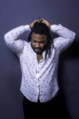 Koyu tenli adam saçlarını rastayla düzeltiyor..