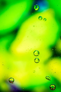 Yeşil renklere sahip soyut bir arkaplan üzerine yağ damlaları.