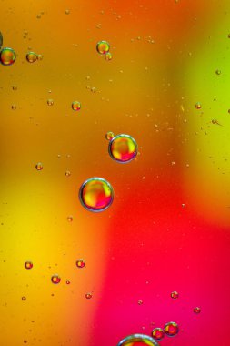 Sarı ve kırmızı renklerle soyut bir arkaplan üzerine yağ damlaları