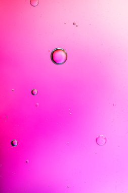 Su yüzeyine pembe renklerde yağ damlaları düşer.