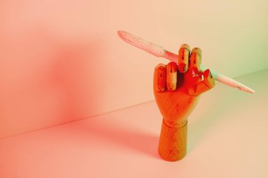 Kırmızı ışıklı beyaz bir boya fırçası olan tahta el.